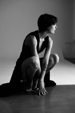 Dramatik geometrik ışıklandırma ile derin düşüncelere dalmış bir kadının karamsar stüdyo fotoğrafı