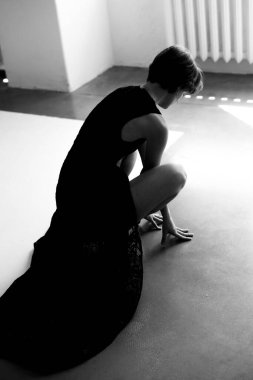 Düşünceli bir kadın portresi. Isıtma radyatörünün yanında, yumuşak pencere ışıklandırmalı.