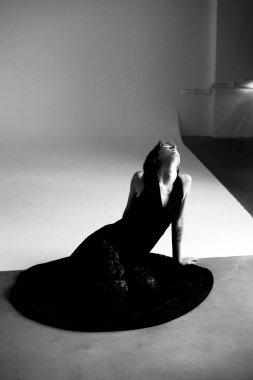 Profesyonel moda fotoğrafçılığı. Siyah elbiseli zarif bir kadın ve stüdyo ışıkları.