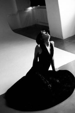 Çağdaş siyah elbiseli kadın portresi dramatik mimari stüdyo ışıklandırmasıyla