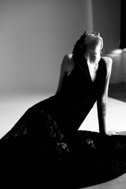 Profesyonel moda fotoğrafçılığı. Siyah elbiseli kadın. Minimalist geometrik arkaplan.