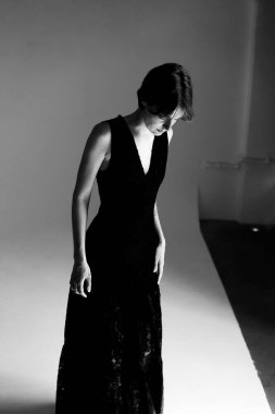 Gece kıyafetli zarif bir kadının tek renkli portresi. Düşünceli bir şekilde aşağıya bakıyor.