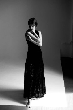 Sanatsal siyah-beyaz kadın portresi. Kendini kucaklayan bir jest.