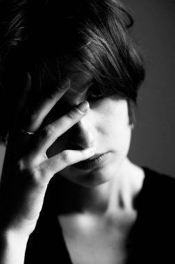 Siyah beyaz stüdyo resimli kolsuz bir kadın. Yüzünde sanatsal bir el izi var.