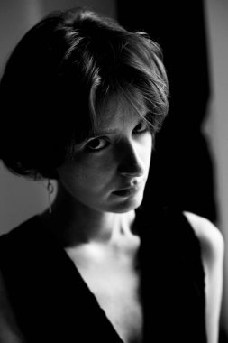 Çağdaş stüdyo fotoğrafçılık teknikleri sergileyen kısa siyah saçlı bir kadının sanatsal monokrom portresi