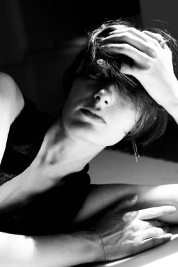 Stüdyo ışıklarıyla yüzünü kapatmış bir kadının çıplak resimlerini inceliyorum.