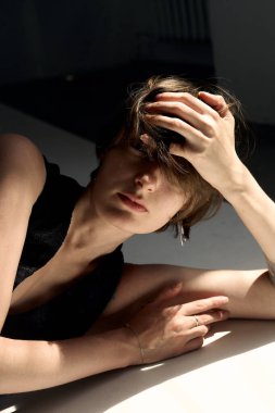 Sıcak tonlu sanatsal çıplak portre. Düşünceli bir kadın ve doğal ışıklandırma.