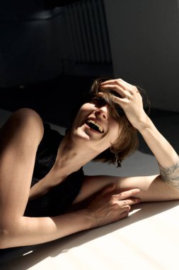 Sıcak ışıklandırmalı sanatsal çıplak portre zarif ifade eden bir kadını gösteriyor.