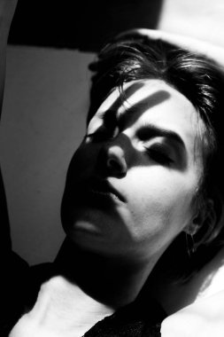 Monokrom sanatsal çıplak çalışma dramatik gölge kontrastı ile ifade eden poziyonda bir kadın yakalamak