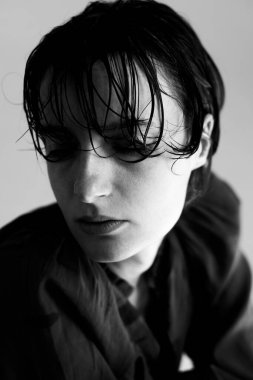 Yumuşak doğal aydınlatmalı koyu renk saçlı, dalgın ifadeyi vurgulayan karamsar yakın plan portresi.