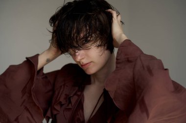 Burgundy blazer ceketli genç adam. Alnında stresli bir stüdyo portresi var.