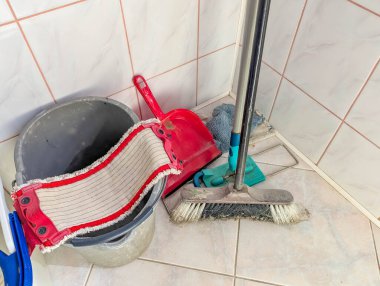 Kırmızı temizlik kovası, paspas ve temizleme aletleri fayanslı zeminde banyo köşesinde depolanmış. yüksek kaliteli fotoğraf
