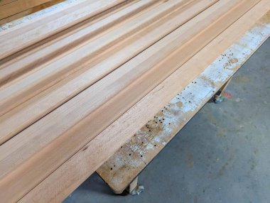 Uzun ahşap tahtalar, kereste işlemede hassasiyet ve kalite kontrolünü gösteren atölye zeminine mükemmel bir şekilde dizilmiştir. Yüksek kalite fotoğraf