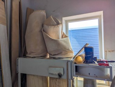 Marangoz atölyesi. Parlak pencerenin yanına yerleştirilmiş alet ve malzemeler. Detaylı iş için doğal ışıklandırma sağlıyor. Yüksek kalite fotoğraf