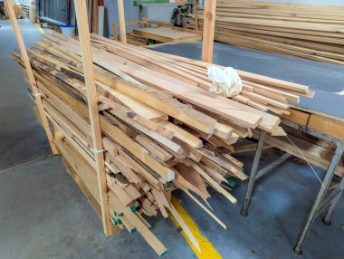 İnşaat ve bitirme işleri için atölye raflarında düzenli olarak düzenlenmiş uzun ahşap şeritler ve kalıp parçaları. Yüksek kalite fotoğraf