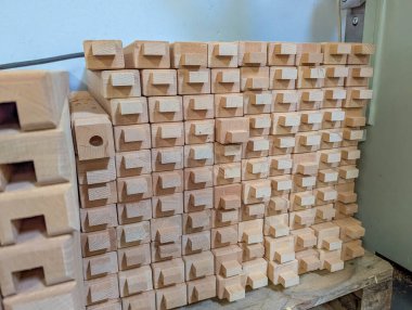 Endüstriyel marangozluk tesisinde düzenlenmiş içi boş dikdörtgen çapraz kesitli büyük ahşap kirişler koleksiyonu. Yüksek kalite fotoğraf