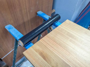 Marangozluk atölyesinde ahşap parçaları güvenceye alan mavi kıskaçlar profesyonel marangozluk tekniklerini gösteriyor. Yüksek kalite fotoğraf