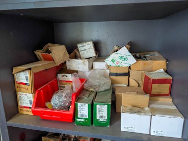 Varşova, Polonya, 20 Eylül 2025. Verimli malzeme yönetimi için atölye ortamında çeşitli karton kutular ve konteynırlarla dolu düzenli depolama ünitesi. Yüksek kalite fotoğraf