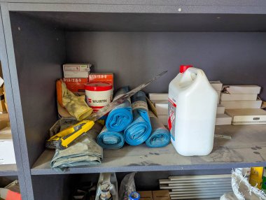 Marangozluk projeleri sırasında kolay erişim için düzenlenmiş çeşitli şişe, konteynır ve malzemeleri içeren atölye deposu rafı. Yüksek kalite fotoğraf