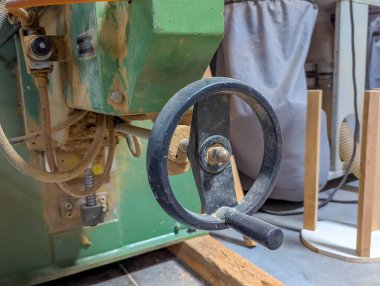 Marangozluk tesisi ortamında endüstriyel tasarım ve işlevsel mühendislik gösteren yeşil atölye mekanizması veya ekipman bileşeni. Yüksek kalite fotoğraf