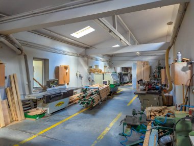 Warsaw, Poland, September 20, 2025. Spacious woodworking workshop with organized tool storage and natural lighting from skylights above work areas. High quality photograph