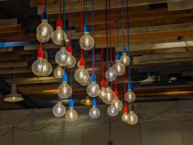 Sanayi tipi kolye lambaları, ahşap tavandan sarkan ampuller ticari alanda atmosferik rustik iç aydınlatma tasarımı yaratıyor. Yüksek kalite fotoğraf