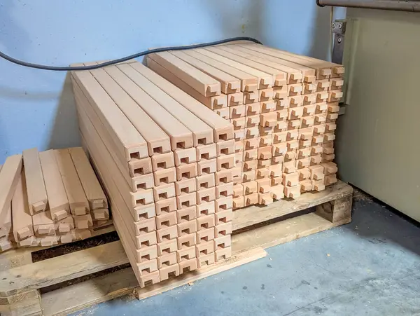 Proje montajı için inşaat malzemesi hazırlıklarını gösteren organize yığının içindeki deliklerle istiflenmiş ahşap bloklar. yüksek kaliteli fotoğraf