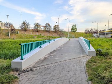 Kırsal yolda uzanan mavi raylı modern yaya köprüsü güvenli geçiş için yolları birleştiriyor. Yüksek kalite fotoğraf