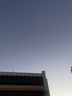 Şehir çatısı bacası açık mavi gökyüzüne karşı şehir manzarası perspektifinde minimalist mimari detaylar yaratıyor. Yüksek kalite fotoğraf