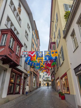 ZURICH, SWITZERLAND, September 20, 2025 Colorful cantonal flags hanging above narrow cobblestone street in historic Old Town district of Zurich, Switzerland creating festive atmosphere. High quality photograph