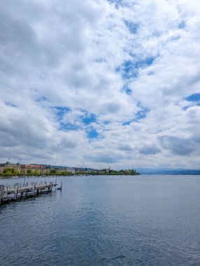 Zürih, İsviçre, 20 Eylül 2025. İsviçre 'de Zürih Gölü manzaralı, tekneli ve deniz kıyısında, dramatik bulutlu bir gökyüzü altında. Yüksek kalite fotoğraf.