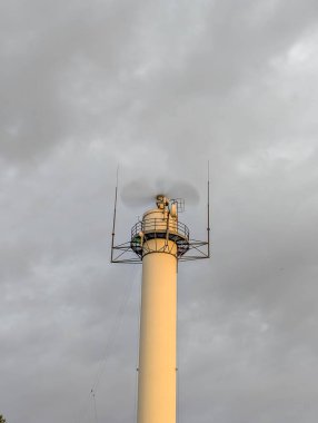 Leba lighthouse standing tall against gray dramatic sky long exposure photography on Baltic coast Poland architectural landmark. High quality photograph