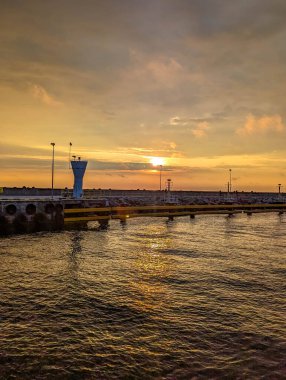 Baltık Denizi sularına yansıyan altın gün batımı, Polonya 'nın alacakaranlık sahnesindeki Leba deniz fenerinin silueti ile birlikte. Yüksek kalite fotoğraf