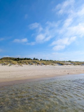 Leba Polonya Baltık kıyısı yakınlarında, bulutlu gökyüzünün altında sığ su havuzları ve kumulları olan geniş kumlu bir sahil. Yüksek kalite fotoğraf