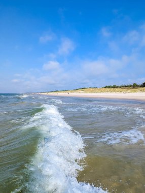 Yazın Leba kasabası Polonya yakınlarındaki kumlu sahil kıyılarına beyaz köpüklü yeşil Baltık Denizi dalgaları yaklaşıyor. Yüksek kalite fotoğraf