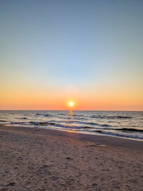 Leba Polonya yakınlarında gün batımında el değmemiş Baltık Denizi sahili altın gökyüzü ve kumlu kıyıları silip süpürüyor. Yüksek kalite fotoğraf