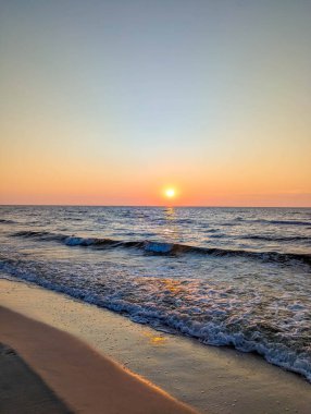Gün batımında Leba Polonya yakınlarında, Baltık Denizi 'nin sakin sahillerinde altın ışık hafif dalgaları yansıtıyor. Yüksek kalite fotoğraf