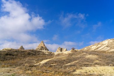 Cappadocia 'nın heybetli taş tepeleri göz kamaştırıcı mavi bir arkaplanla aşınmış.