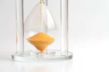 Altın kum saatinin alt odasının yakın görüntüsü, iş teslim tarihlerini, aciliyeti ve zaman yönetimini temsil ediyor.