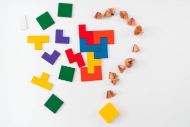 Belirsizlik, problem çözme ve yaratıcı süreç kavramları. Kalem tıraşından elde edilen büyük bir soru işaretiyle yan yana yerleştirilmiş çözülmemiş renkli bir blok bulmacası tarafından sembolize edilmiştir.