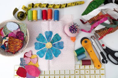 Üst görünüm dikişe hazır çiçek uygulaması, arta kalan kumaşlar ve yorgan dikme ve dikiş malzemeleri; el yapımı el işi için yeniden kullanım malzemesi kavramı