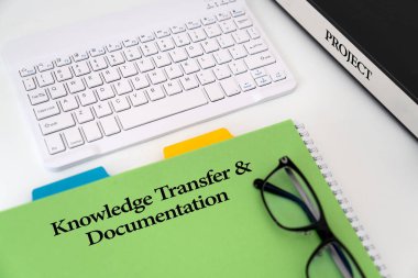 'Bilgi Aktarımı ve Belgelendirme' için resimli fotoğraf 'Bilgi Aktarımı ve Belgelendirmesi' başlıklı yeşil bir belgenin yer aldığı bir proje, 'Proje' etiketli bir klavye, gözlük ve klasör