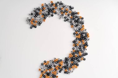 Dağılmış harfler ve sayılar, merak, analiz ve cevapların arayışını sembolize eden büyük bir soru işaretini şekillendirir.