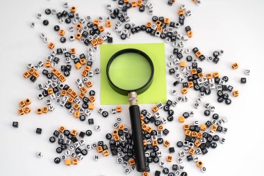 Bir büyüteç altında büyütülmüş boş bir kağıt. Etrafı dağınık harf ve sayılarla çevrili. Keşif potansiyelini, yorumlamayı ve anlamın oluşumunu sembolize ediyor.