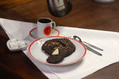 Bir fincan kahve, şeker küpleri ve kurabiyeler eski 70 'lerin ahşap tabaklarında..