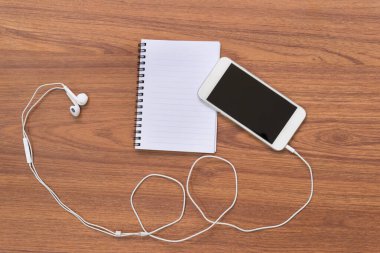 Smartphone ve ahşap masa üstünde defter