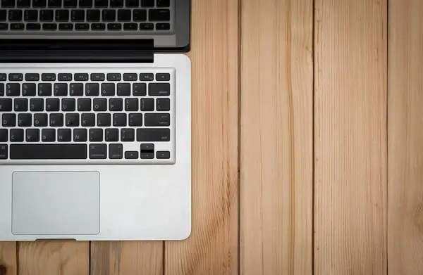 Dizüstü bilgisayarı ve defteri olan modern ahşap ofis masasının en üst görüntüsü. Kopyalama alanı mevcut.