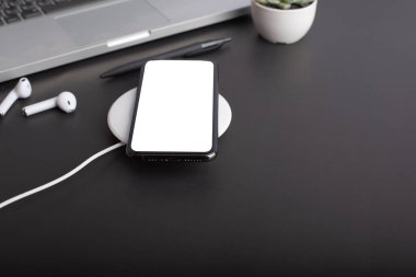 Bilgisayarı, akıllı telefonu ve malzemeleri olan siyah ofis masası. Kopyalama alanı olan üst görünüm, düz yatay.