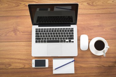 Ahşap masa üzerindeki mali belgeler ile dizüstü bilgisayar, akıllı telefon ve kahve Kupası