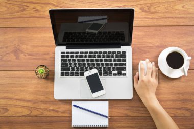 Ofis İşyeri dizüstü bilgisayar ve ahşap masa üstünde smartphone. Yukarıdan görüntülemek